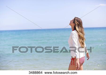 Pretty blonde woman enjoying at the beach with arms opened View Large Photo Image Picture - Pretty blonde woman enjoying at the beach with arms opened. Fotosearch