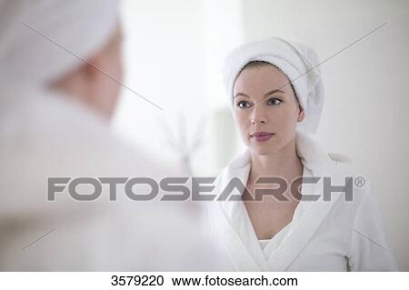 Pretty blonde woman in bathrobe looking herself in the mirror View Large Photo Image Stock Image - Pretty blonde woman in bathrobe looking herself in the mirror. Fotosearch