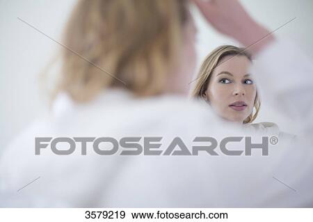 Pretty blonde woman in bathrobe looking herself in the mirror View Large Photo Image Stock Photo - Pretty blonde woman in bathrobe looking herself in the mirror. Fotosearch