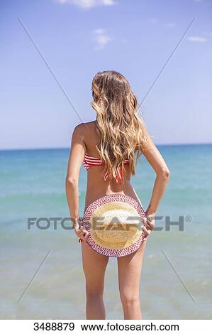 Pretty blonde woman in bikini hiding her bottom at the beach looking at the horizon View Large Photo Image Stock Photo - Pretty blonde woman in bikini hiding her bottom at the beach looking at the horizon. Fotosearch