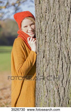 Pretty blonde woman leaning on a tree in park in autumn View Large Photo Image Stock Image - Pretty blonde woman leaning on a tree in park in autumn. Fotosearch