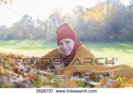 Pretty blonde woman lying in park in autumn smiling at camera View Large Photo Image Stock Photo - Pretty blonde woman lying in park in autumn smiling at camera. Fotosearch