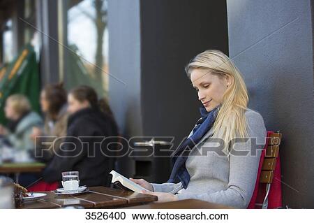 Pretty blonde woman reading a book in a Cafe in downtown View Large Photo Image Stock Image - Pretty blonde woman reading a book in a Cafe in downtown. Fotosearch