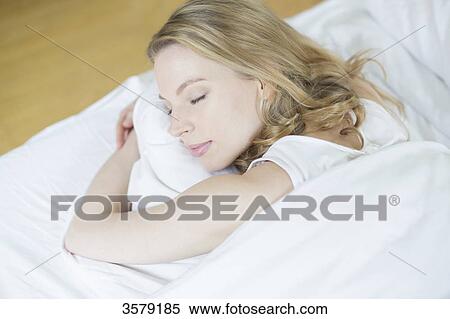 Stock Photography - Pretty blonde woman sleeping in bed. Fotosearch