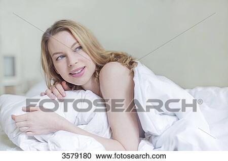 Pretty blonde woman smiling in bed View Large Photo Image Stock Image - Pretty blonde woman smiling in bed. Fotosearch
