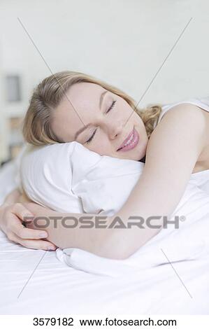 Pretty blonde woman smiling with eyes closed in bed View Large Photo Image Stock Image - Pretty blonde woman smiling with eyes closed in bed. Fotosearch