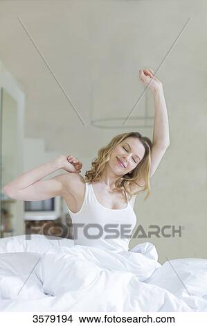Pretty blonde woman stretching in bed in the morning View Large Photo Image Picture - Pretty blonde woman stretching in bed in the morning. Fotosearch