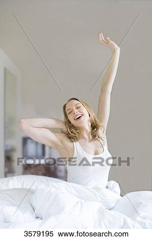 Pretty blonde woman stretching in bed in the morning View Large Photo Image Stock Photography - Pretty blonde woman stretching in bed in the morning. Fotosearch