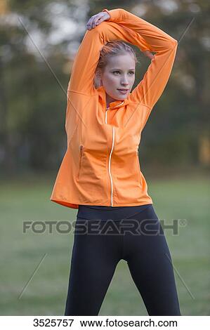 Pretty blonde woman stretching in park View Large Photo Image Stock Photo - Pretty blonde woman stretching in park. Fotosearch