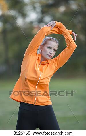 Pretty blonde woman stretching in park View Large Photo Image Stock Photo - Pretty blonde woman stretching in park. Fotosearch