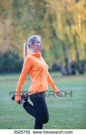 Pretty blonde woman stretching in park View Large Photo Image Stock Photography - Pretty blonde woman stretching in park. Fotosearch