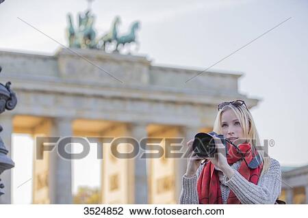 Pretty blonde woman taking photos in front of the Brandenburg Gate in Berlin View Large Photo Image Stock Image - Pretty blonde woman taking photos in front of the Brandenburg Gate in Berlin. Fotosearch