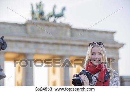 Pretty blonde woman taking photos in front of the Brandenburg Gate in Berlin and looking at camera View Large Photo Image Stock Image - Pretty blonde woman taking photos in front of the Brandenburg Gate in Berlin and looking at camera. Fotosearch