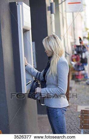 Pretty blonde woman using a cash machine View Large Photo Image Stock Photo - Pretty blonde woman using a cash machine. Fotosearch