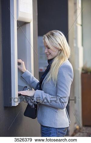 Pretty blonde woman using a cash machine View Large Photo Image Stock Photo - Pretty blonde woman using a cash machine. Fotosearch