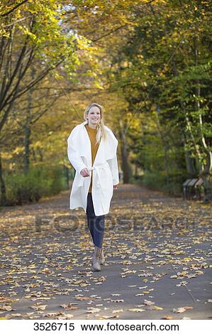 Stock Photography - Pretty blonde woman walking in Park in Autumn. Fotosearch