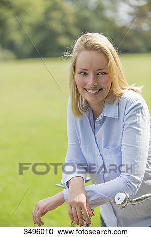 Pretty blonde woman with bicycle in park View Large Photo Image Stock Image - Pretty blonde woman with bicycle in park. Fotosearch