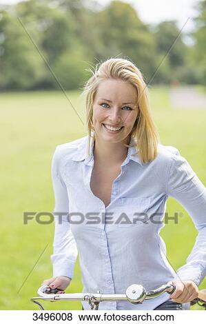 Pretty blonde woman with bike in park View Large Photo Image Stock Photo - Pretty blonde woman with bike in park. Fotosearch