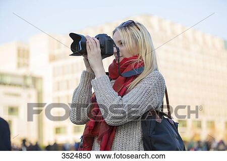 Pretty blonde woman with digital camera taking photos in a city in Europe View Large Photo Image Stock Image - Pretty blonde woman with digital camera taking photos in a city in Europe. Fotosearch