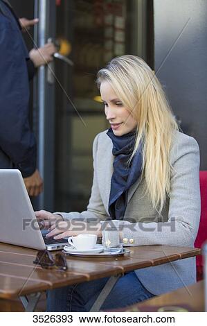 Pretty blonde woman with laptop in a Cafe View Large Photo Image Stock Image - Pretty blonde woman with laptop in a Cafe. Fotosearch
