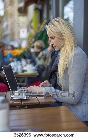 Pretty blonde woman with laptop in a Cafe View Large Photo Image Stock Photograph - Pretty blonde woman with laptop in a Cafe. Fotosearch