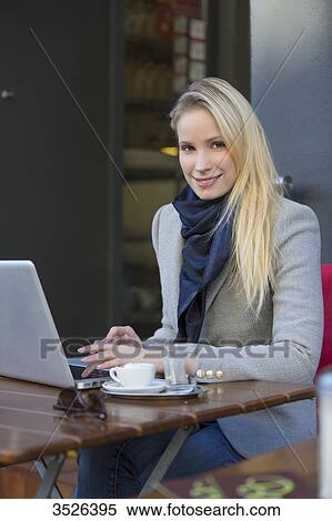 Pretty blonde woman with laptop in a Cafe smiling at camera View Large Photo Image Stock Photography - Pretty blonde woman with laptop in a Cafe smiling at camera. Fotosearch
