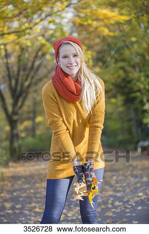 Pretty blonde woman with leaves in park in autumn View Large Photo Image Stock Photo - Pretty blonde woman with leaves in park in autumn. Fotosearch