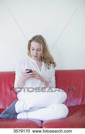 Pretty blonde woman with mobile on the couch View Large Photo Image Stock Image - Pretty blonde woman with mobile on the couch. Fotosearch