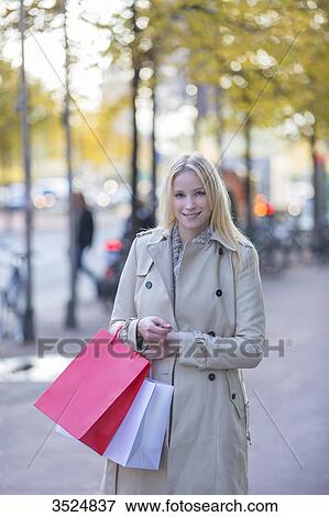Pretty blonde woman with shopping bags walking in downtown View Large Photo Image Stock Photo - Pretty blonde woman with shopping bags walking in downtown. Fotosearch