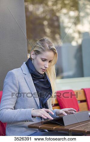 Pretty blonde woman with tablet in a Cafe View Large Photo Image Stock Image - Pretty blonde woman with tablet in a Cafe. Fotosearch