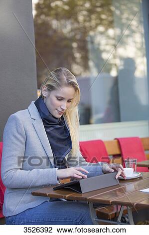 Pretty blonde woman with tablet in a Cafe View Large Photo Image Stock Image - Pretty blonde woman with tablet in a Cafe. Fotosearch