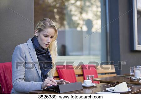 Pretty blonde woman with tablet in a Cafe View Large Photo Image Stock Photo - Pretty blonde woman with tablet in a Cafe. Fotosearch