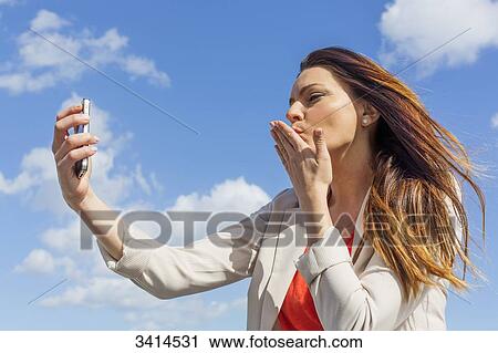 Pretty brunette woman doing a selfie with smartphone View Large Photo Image Stock Image - Pretty brunette woman doing a selfie with smartphone. Fotosearch