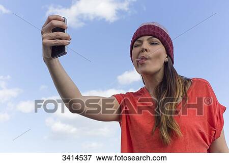Pretty brunette woman doing a selfie with smartphone View Large Photo Image Stock Photo - Pretty brunette woman doing a selfie with smartphone. Fotosearch