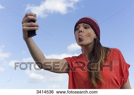 Pretty brunette woman doing a selfie with smartphone View Large Photo Image Stock Photograph - Pretty brunette woman doing a selfie with smartphone. Fotosearch