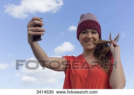 Pretty brunette woman doing a selfie with smartphone View Large Photo Image Stock Photography - Pretty brunette woman doing a selfie with smartphone. Fotosearch