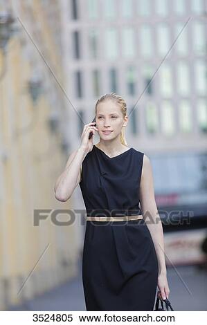 Pretty business woman with bag and talking on the phone, walking in downtown View Large Photo Image Stock Photography - Pretty business woman with bag and talking on the phone, walking in downtown. Fotosearch