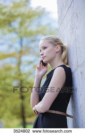 Pretty elegant woman making a call in front of an office building View Large Photo Image Stock Image - Pretty elegant woman making a call in front of an office building. Fotosearch