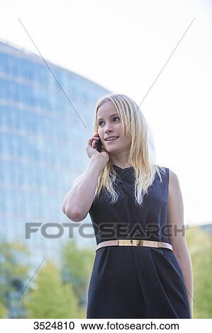 Pretty elegant woman making a call in front of an office building in downtown View Large Photo Image Stock Image - Pretty elegant woman making a call in front of an office building in downtown. Fotosearch
