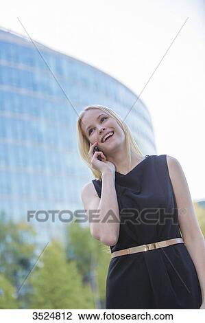 Pretty elegant woman making a call in front of an office building in downtown View Large Photo Image Stock Image - Pretty elegant woman making a call in front of an office building in downtown. Fotosearch