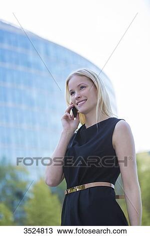 Pretty elegant woman making a call in front of an office building in downtown View Large Photo Image Stock Image - Pretty elegant woman making a call in front of an office building in downtown. Fotosearch