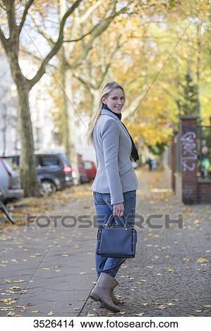 Pretty elegant woman walking with handbag in citycenter View Large Photo Image Picture - Pretty elegant woman walking with handbag in citycenter. Fotosearch
