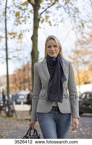 Pretty elegant woman walking with handbag in citycenter View Large Photo Image Stock Image - Pretty elegant woman walking with handbag in citycenter. Fotosearch