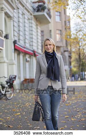 Pretty elegant woman walking with handbag in citycenter View Large Photo Image Stock Photo - Pretty elegant woman walking with handbag in citycenter. Fotosearch