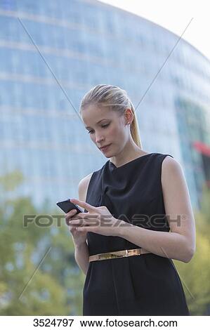 Pretty elegant woman with mobile in front of an office building View Large Photo Image Stock Photo - Pretty elegant woman with mobile in front of an office building. Fotosearch