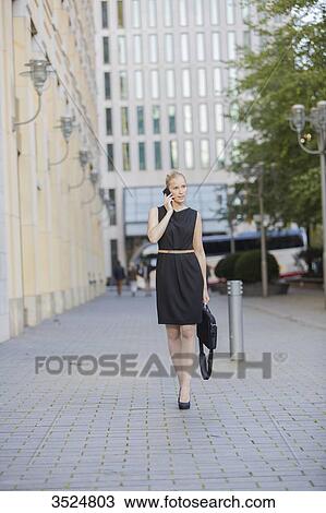 Pretty executive woman with bag talking on the phone in Downtown View Large Photo Image Stock Image - Pretty executive woman with bag talking on the phone in Downtown. Fotosearch