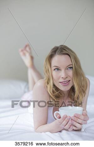 Pretty pensive blonde woman with a cup of tea in bed View Large Photo Image Stock Photograph - Pretty pensive blonde woman with a cup of tea in bed. Fotosearch