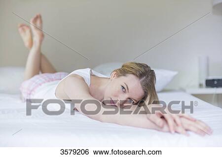 Pretty pensive woman lying in bed View Large Photo Image Stock Photograph - Pretty pensive woman lying in bed. Fotosearch