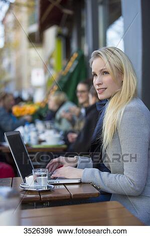 Pretty pensive woman with laptop in a cafe View Large Photo Image Stock Photo - Pretty pensive woman with laptop in a cafe. Fotosearch