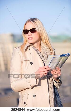 Picture - Pretty touritst woman with map searching for direction with sunglasses. Fotosearch